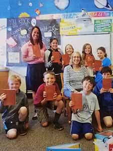 Kids holding the book The Call, by Wendy K. Ulmer