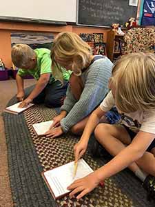 Kids holding the book The Call, by Wendy K. Ulmer